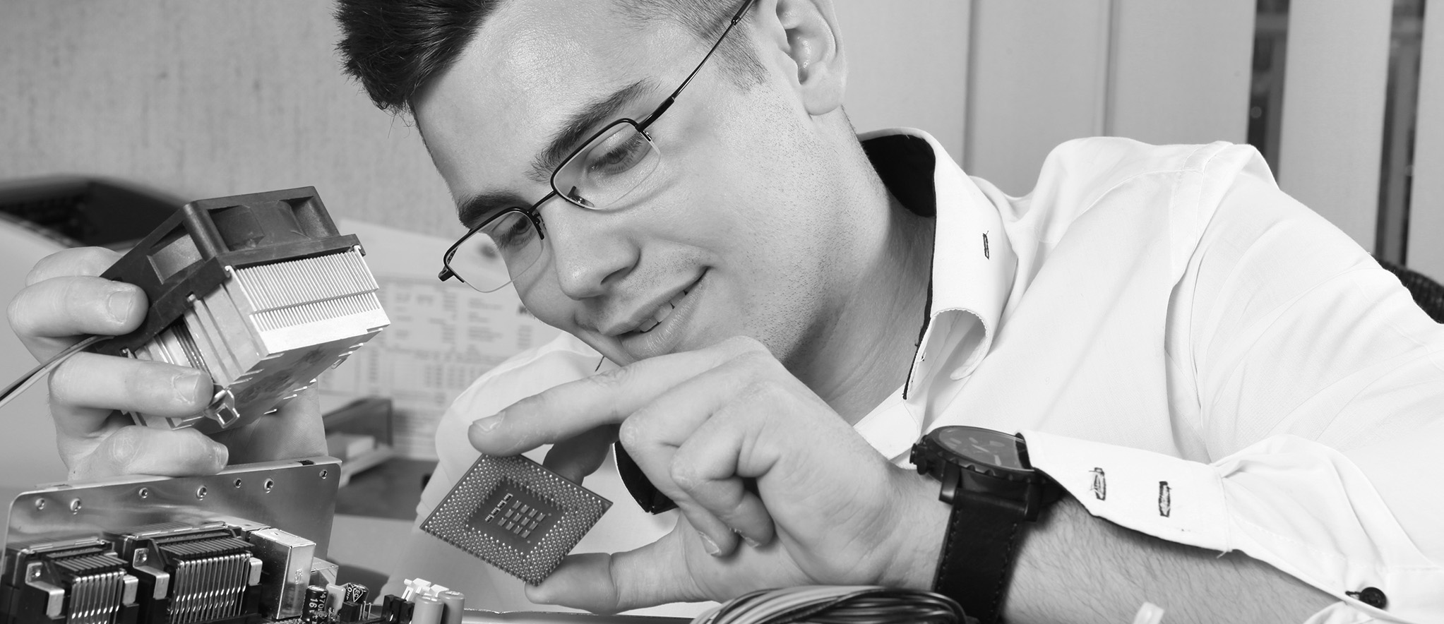 Junger Mann mit Brille unf Computer-Hardware-Teilen in der Hand
